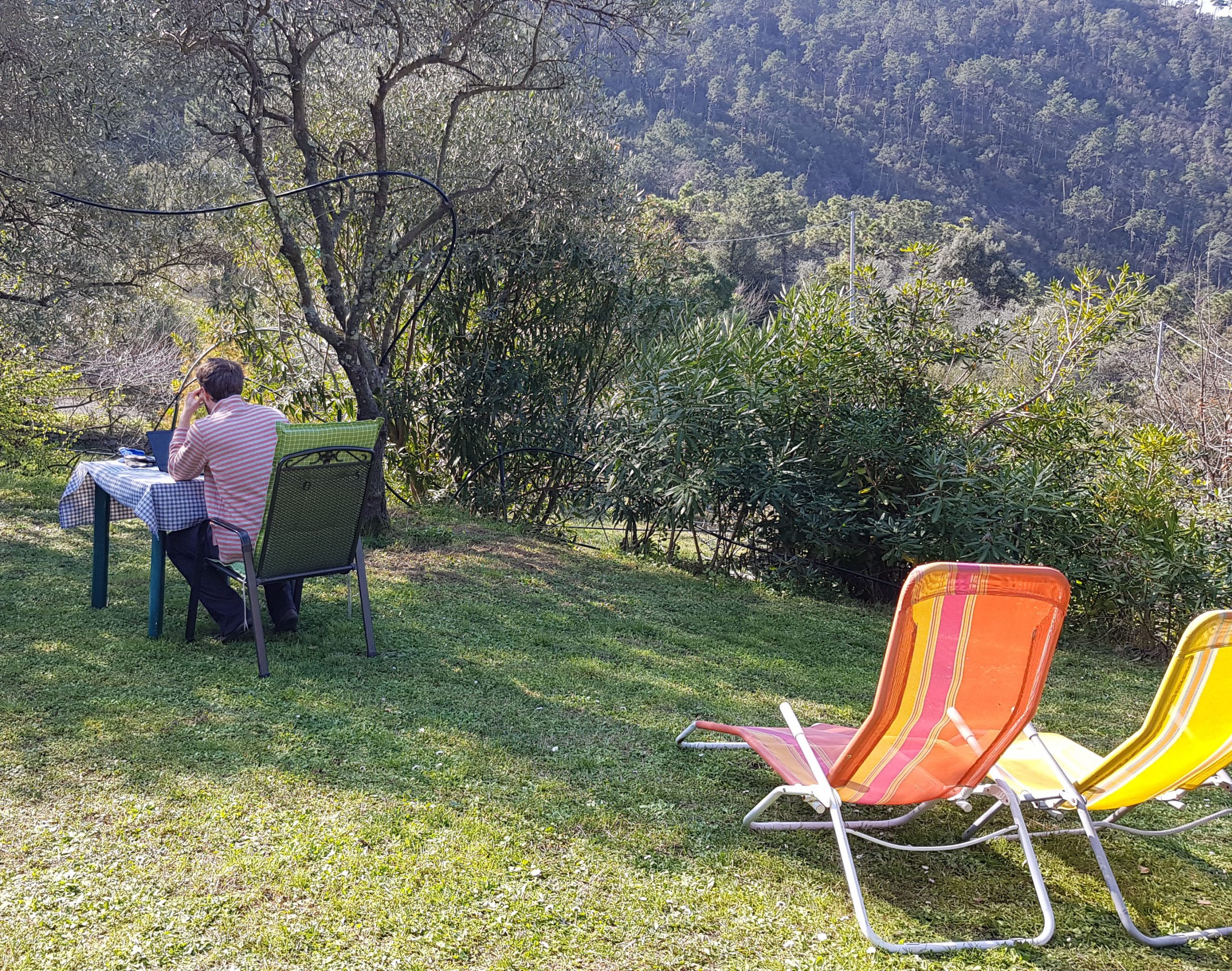 Im italienischen Garten: Zwei Sonnenstühle und Tisch mit Laptop